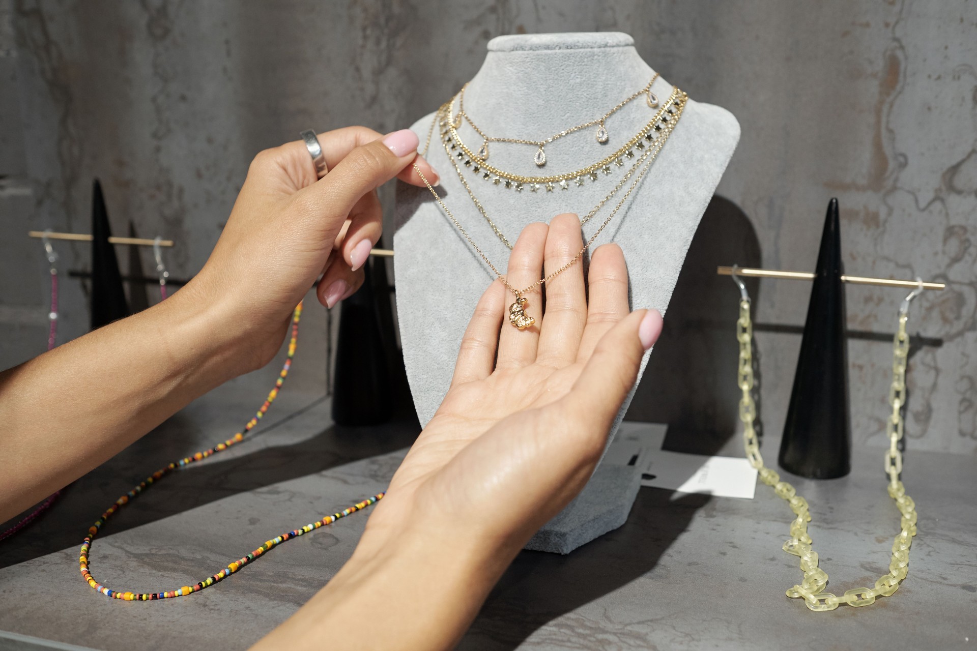 Hands of young woman holding golden chain with pendant